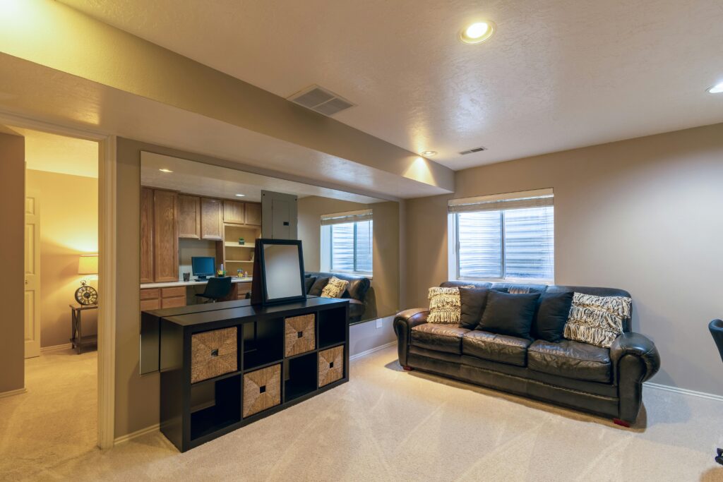 Warm and inviting basement living room featuring a leather sofa and modern decor.